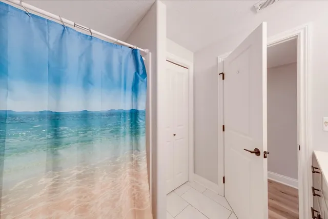 a front view of a house with large trees