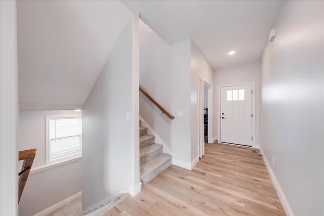 a view of an entryway with wooden floor and staircase