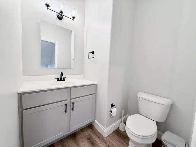 a bathroom with a toilet sink and mirror