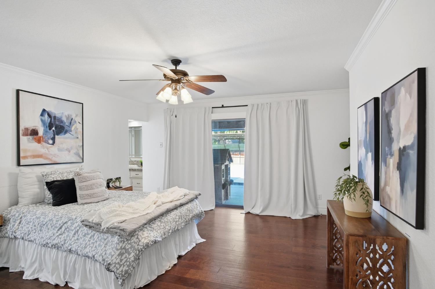 10401 Golf Link Road Turlock, CA 95380 - Photo 18 of 63 a bedroom with a large bed and a chandelier