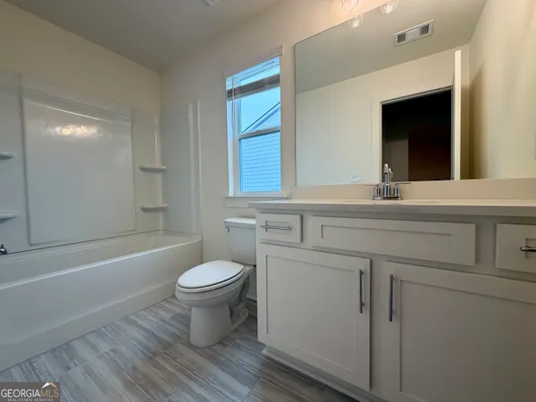 a bathroom with a sink toilet mirror and shower