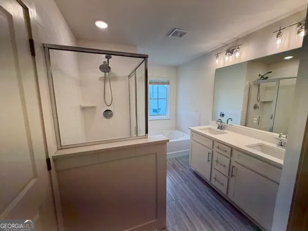 a bathroom with a double vanity sink mirror and shower