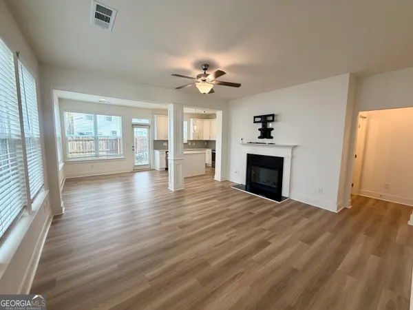 an empty room with wooden floor and fireplace
