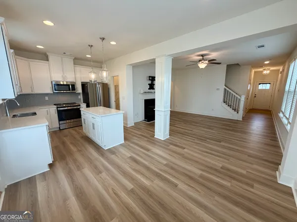 a living room with furniture and kitchen view