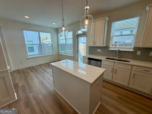 a kitchen with stainless steel appliances granite countertop a sink a stove and a wooden floors