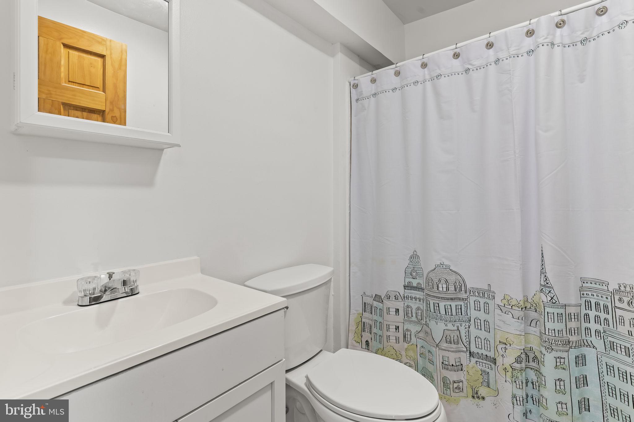 532 Shortbow Trail Lusby, MD 20657 - Photo 26 of 33 a bathroom with a sink a toilet and shower curtain