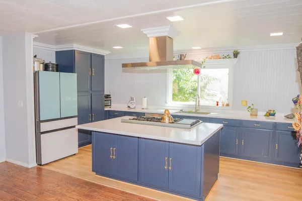 a kitchen with kitchen island granite countertop a sink and refrigerator