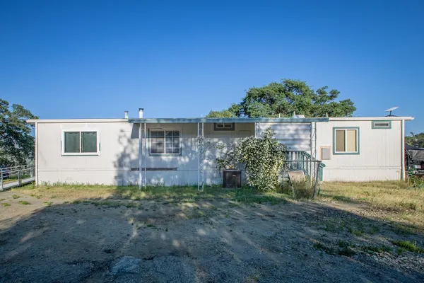 a view of a house with backyard and a tree