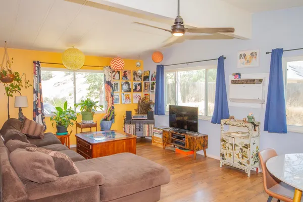 a living room with furniture a flat screen tv and a large window