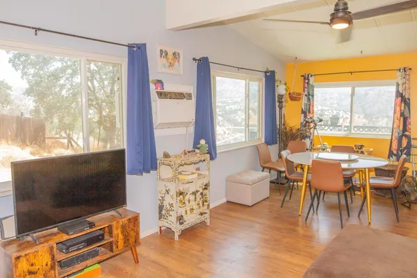 a living room with furniture a flat screen tv and a floor to ceiling window