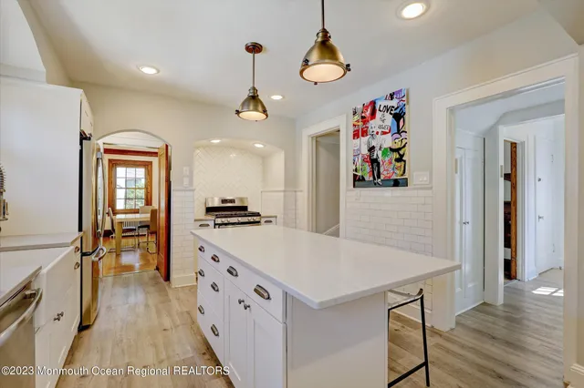 a large kitchen with a lot of counter space and wooden floor