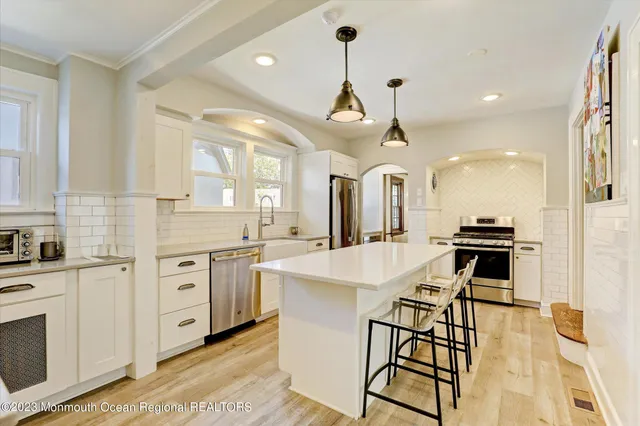 a large kitchen with cabinets a island a stove a chimney a sink and dishwasher