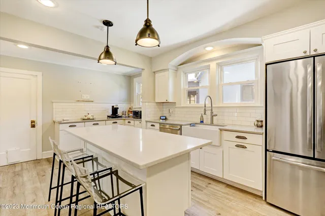 a kitchen with a sink a center island and stainless steel appliances