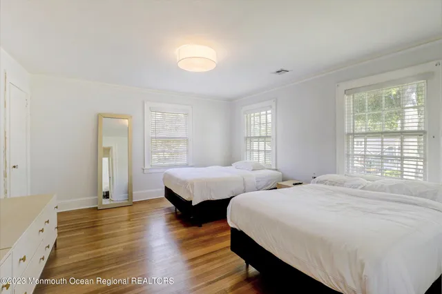 a bedroom with two beds and a dresser