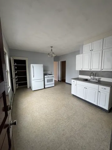 a view of kitchen with cabinets and refrigerator