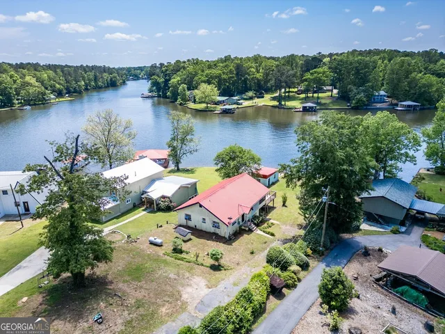 an aerial view of a house with a garden and lake view