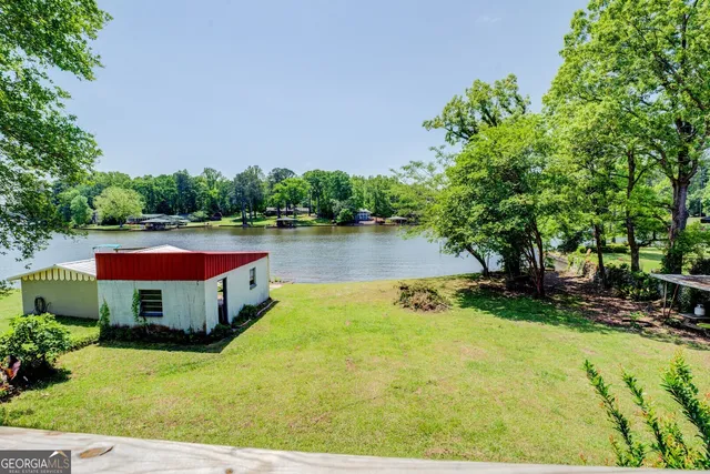 a view of swimming pool with lawn chairs and plants