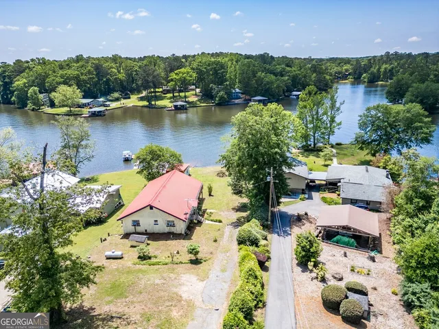 an aerial view of a house with a lake view and a garden