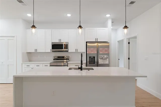 a kitchen with stainless steel appliances a refrigerator sink and microwave