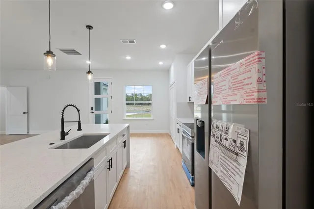 a kitchen with granite countertop a sink a counter top space appliances and cabinets