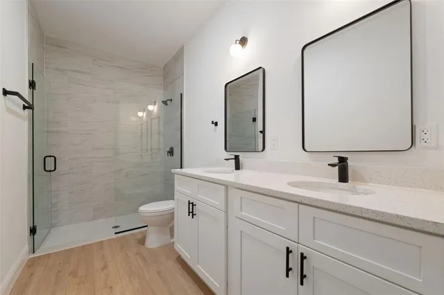a bathroom with a double vanity sink mirror and toilet