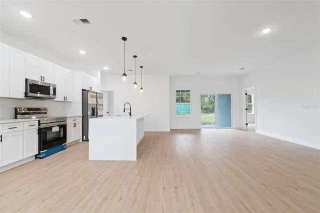 a view of a kitchen with a sink stove top oven and refrigerator