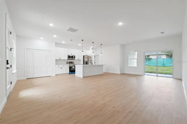 a view of a kitchen with a sink and dishwasher a refrigerator with wooden floor