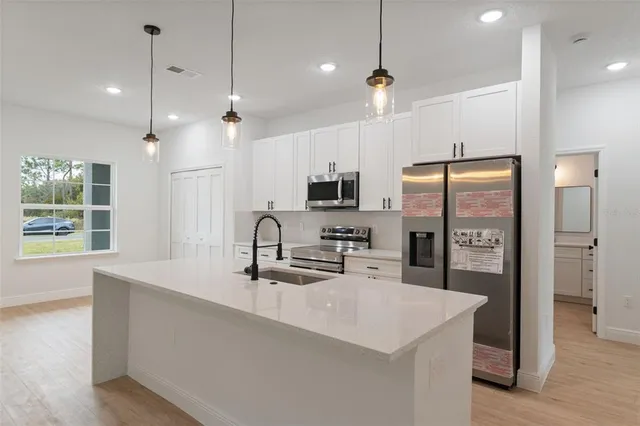 a kitchen with stainless steel appliances a refrigerator a sink and a microwave