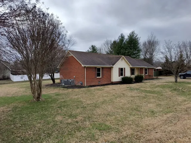 a front view of a house with a yard and trees