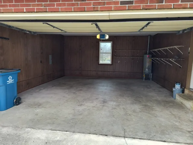 an empty room with wooden floor fire place and windows