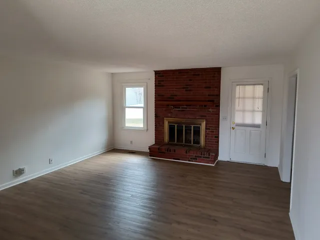 a view of a room with wooden floor and a sink