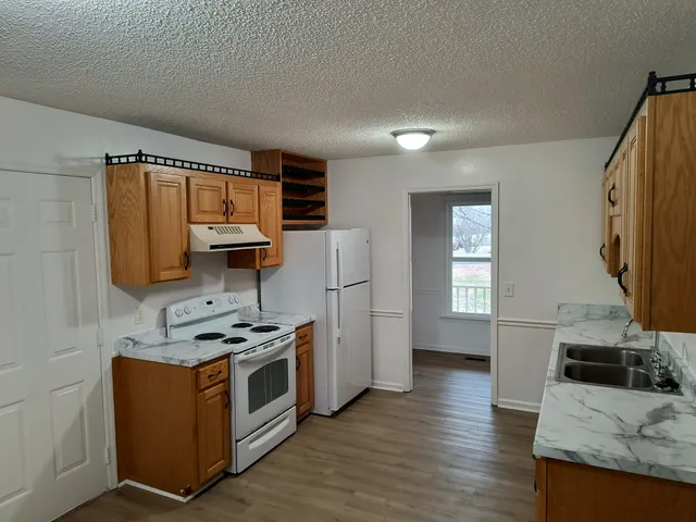 a kitchen with granite countertop a sink stove and cabinets