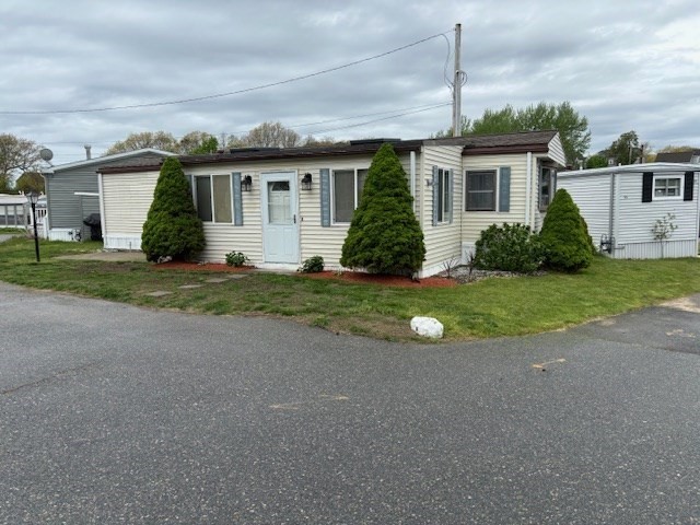 front view of a house and a yard with potted plants