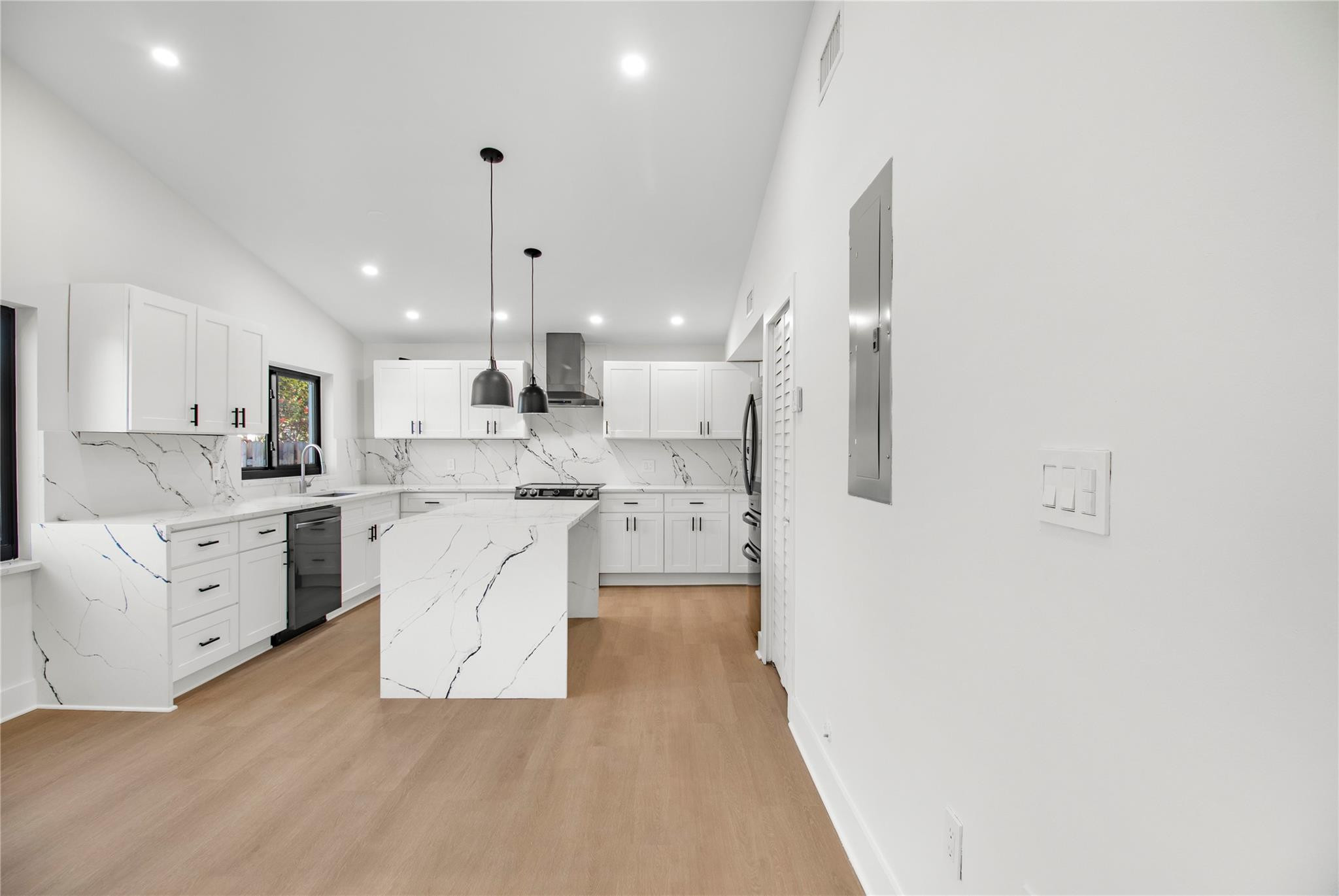 1951 Northeast 28th Court Lighthouse Point, FL 33064 - Photo 16 of 34 a large white kitchen with white cabinets and stainless steel appliances