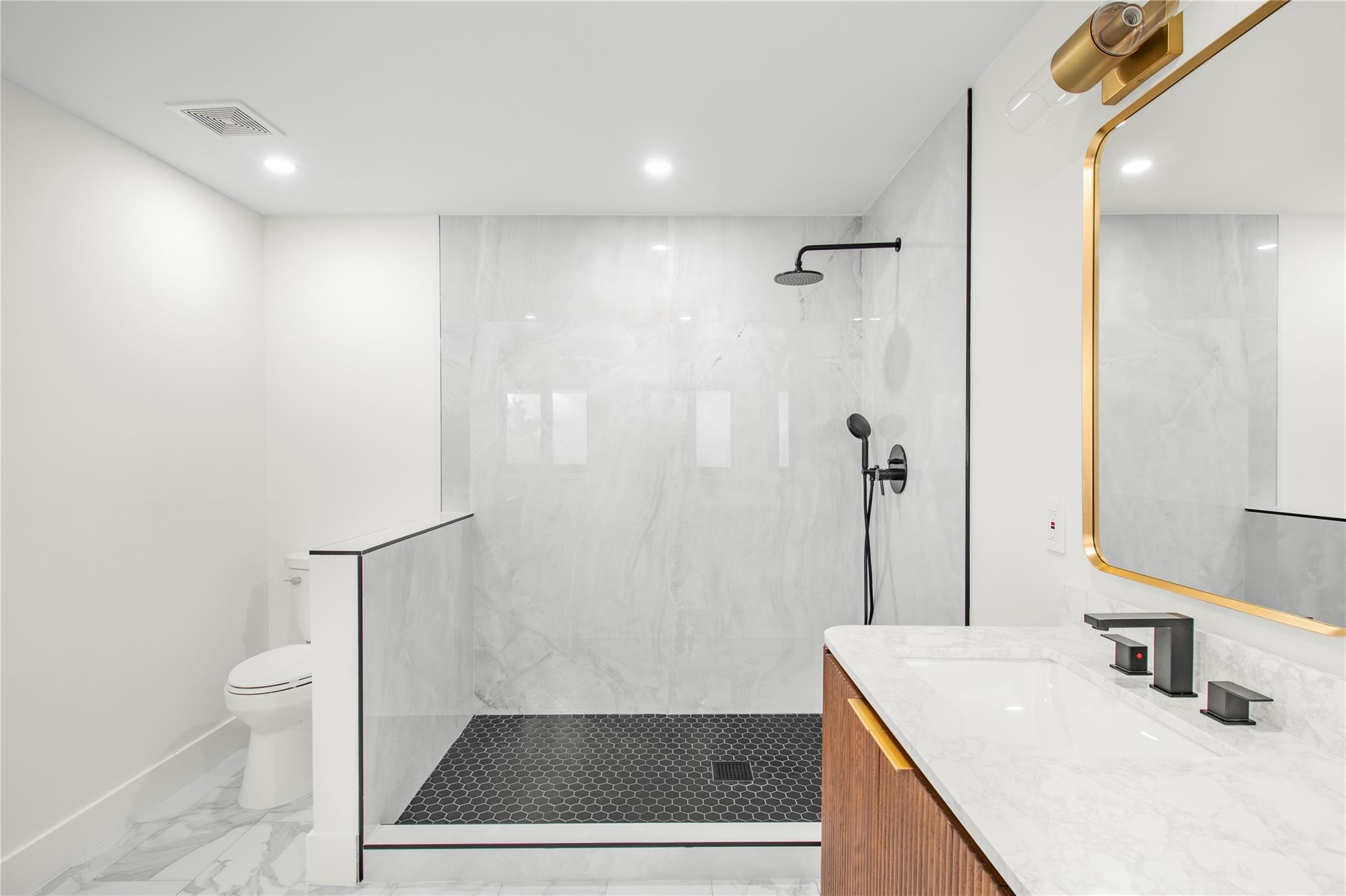 1951 Northeast 28th Court Lighthouse Point, FL 33064 - Photo 7 of 34 a bathroom with a sink a toilet a mirror and shower