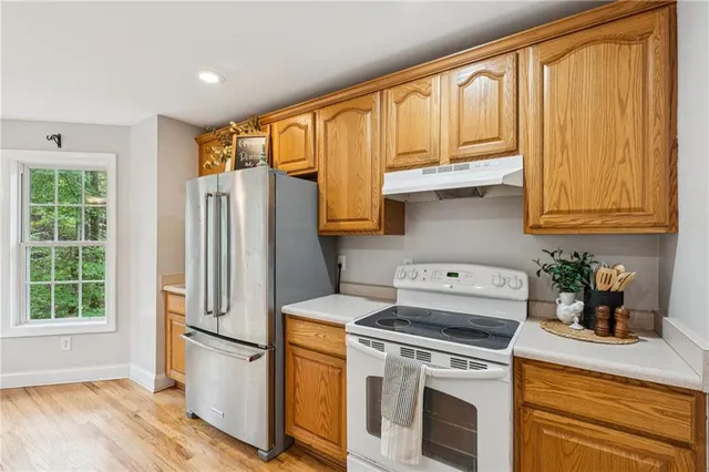 a kitchen with stainless steel appliances granite countertop a refrigerator sink and stove