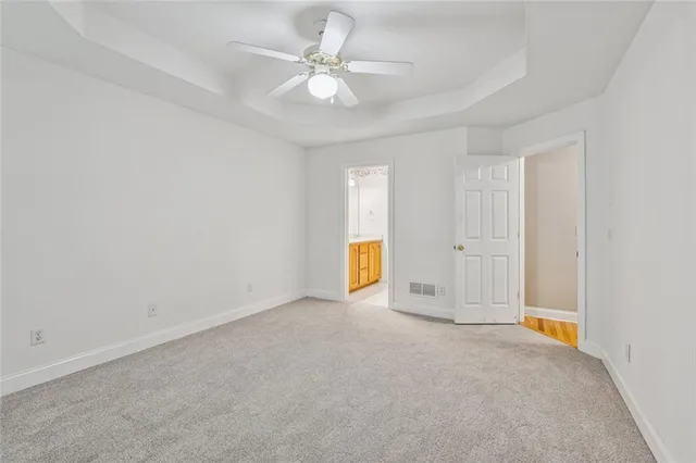 an empty room with a ceiling fan and window