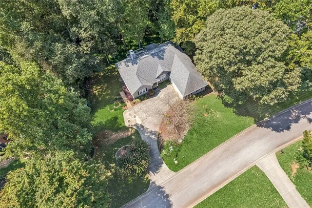 an aerial view of a house with a yard and trees