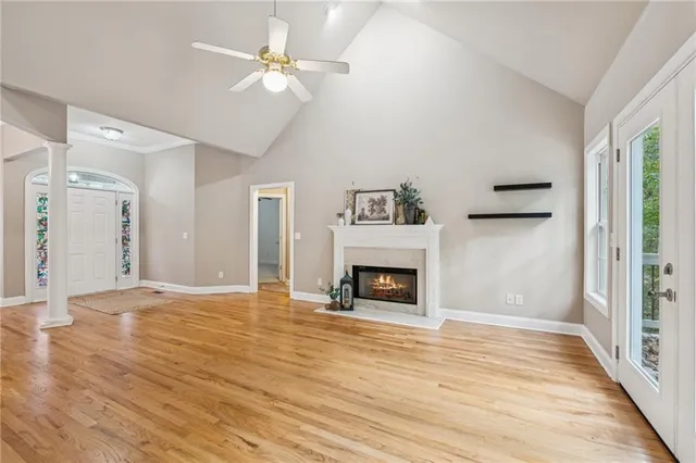a view of empty room with wooden floor and fan