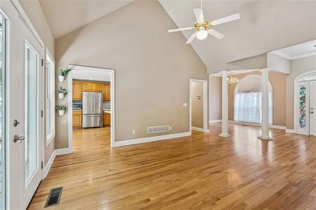 a view of an empty room with window and wooden floor