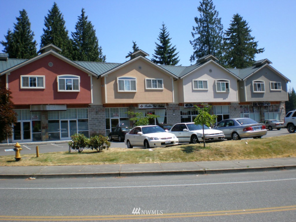 212 West Winesap Road, Unit 104 Bothell, WA 98012 - Photo 1 of 13 a view of a white house with couches chairs and a barbeque
