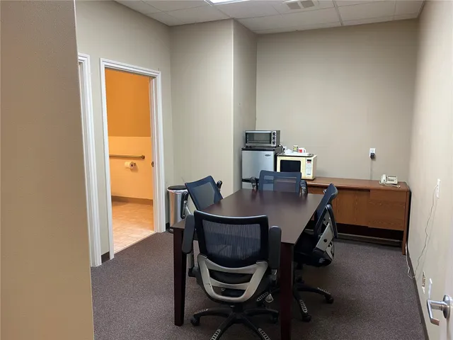 a view of a workspace with furniture and a window