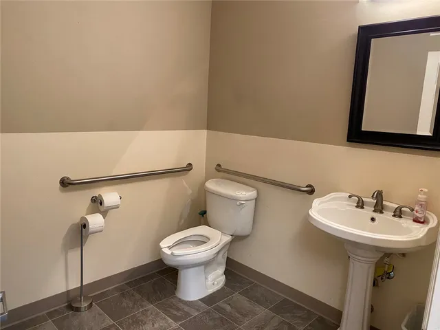 a bathroom with a sink toilet and mirror