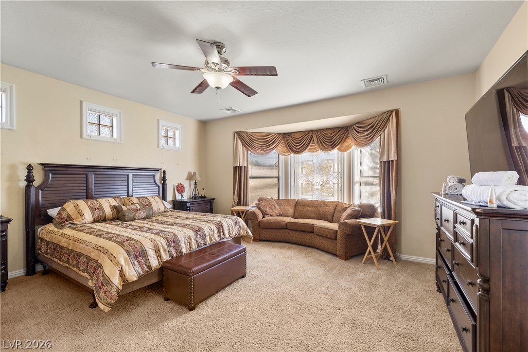 2181 Winery Road Pahrump, NV 89048 - Photo 25 of 52 A restful primary bedroom with a cozy sitting area beneath a gracefully draped bay window.