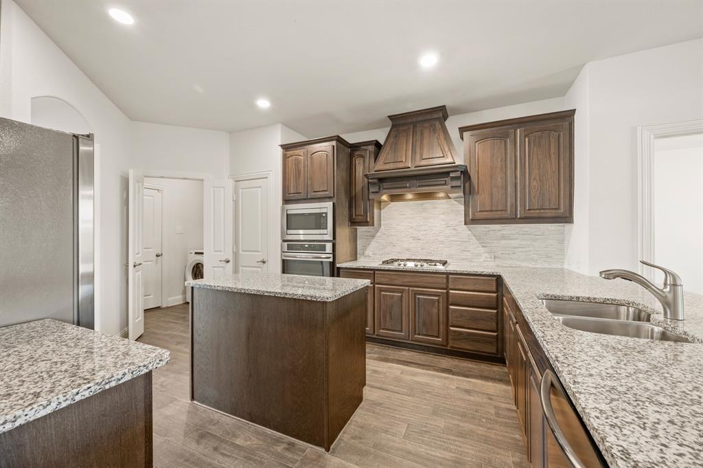 10920 Calvert Place McKinney, TX 75071 - Photo 11 of 37 a kitchen with kitchen island granite countertop a sink stove and refrigerator