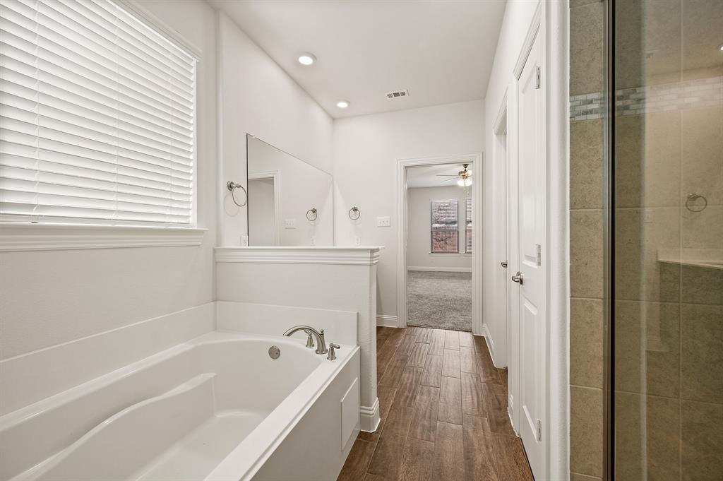 10920 Calvert Place McKinney, TX 75071 - Photo 17 of 37 a bathroom with a bathtub a toilet and a shower
