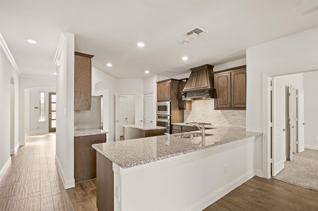 10920 Calvert Place McKinney, TX 75071 - Photo 10 of 37 a kitchen with stainless steel appliances granite countertop a sink and a refrigerator