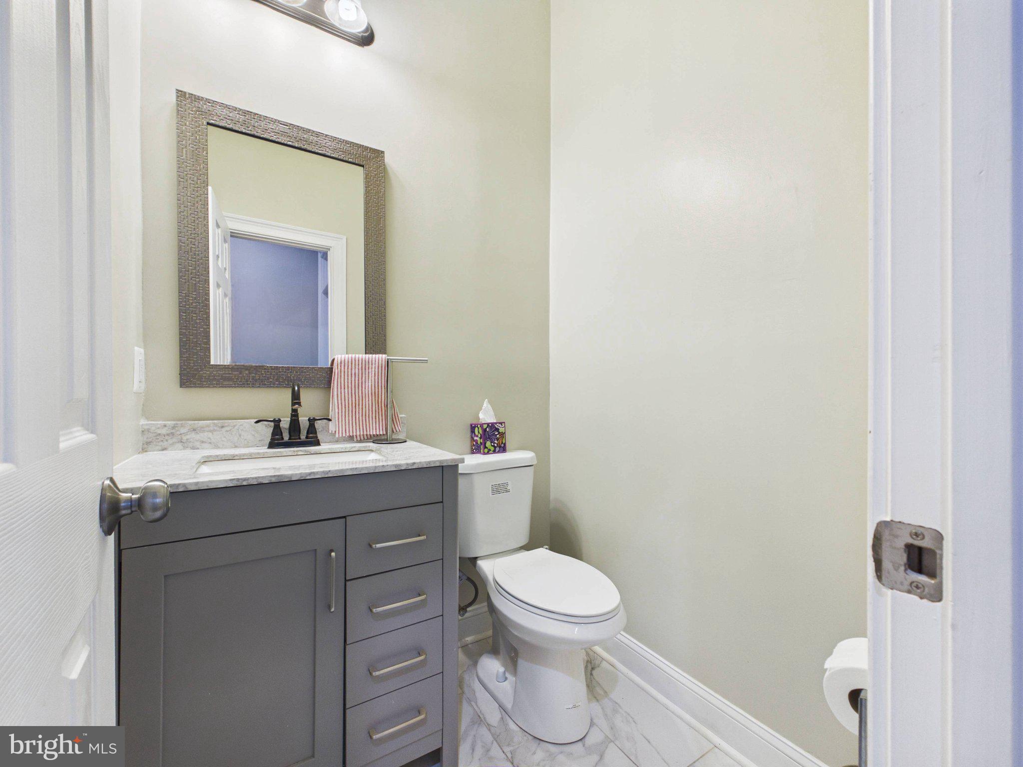 38565 Piggott Bottom Road Hamilton, VA 20158 - Photo 26 of 85 a bathroom with a granite countertop toilet a sink and a mirror