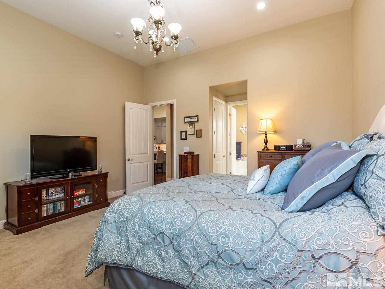9455 Baldacci Road Reno, NV 89521 - Photo 15 of 22 a spacious bedroom with a bed and a flat screen tv