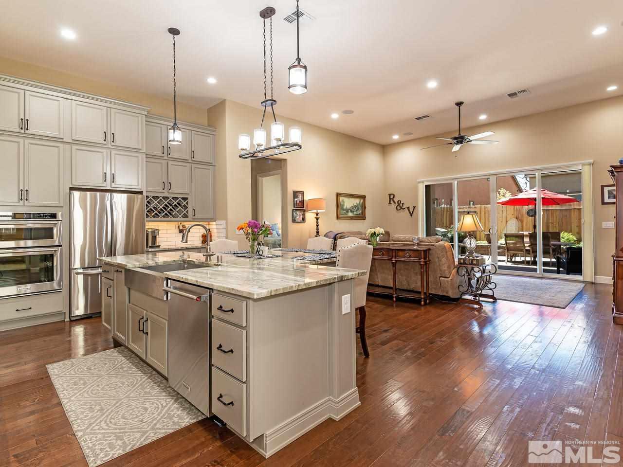 9455 Baldacci Road Reno, NV 89521 - Photo 8 of 22 a kitchen with stainless steel appliances granite countertop a sink a stove and a wooden floor